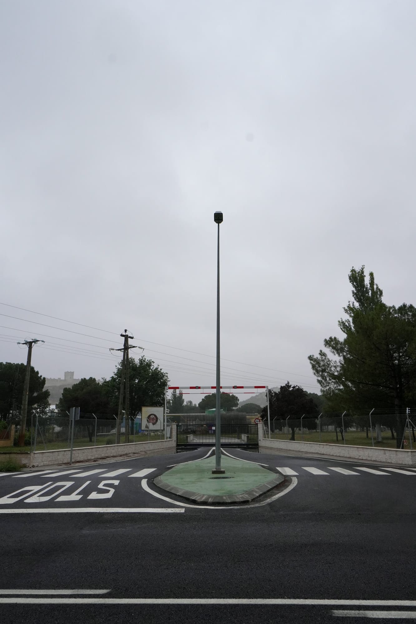 Isleta con farola en el acceso a la fábrica, con el castillo de Peñafiel al fondo