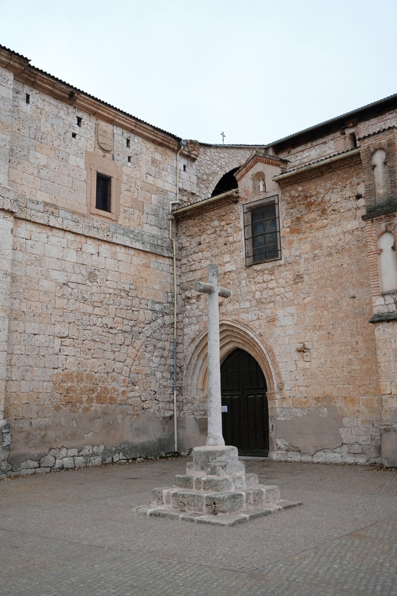 Plaza adoquinada frente a la iglesia de San Pablo, con un crucero de piedra delante de la portada gótica