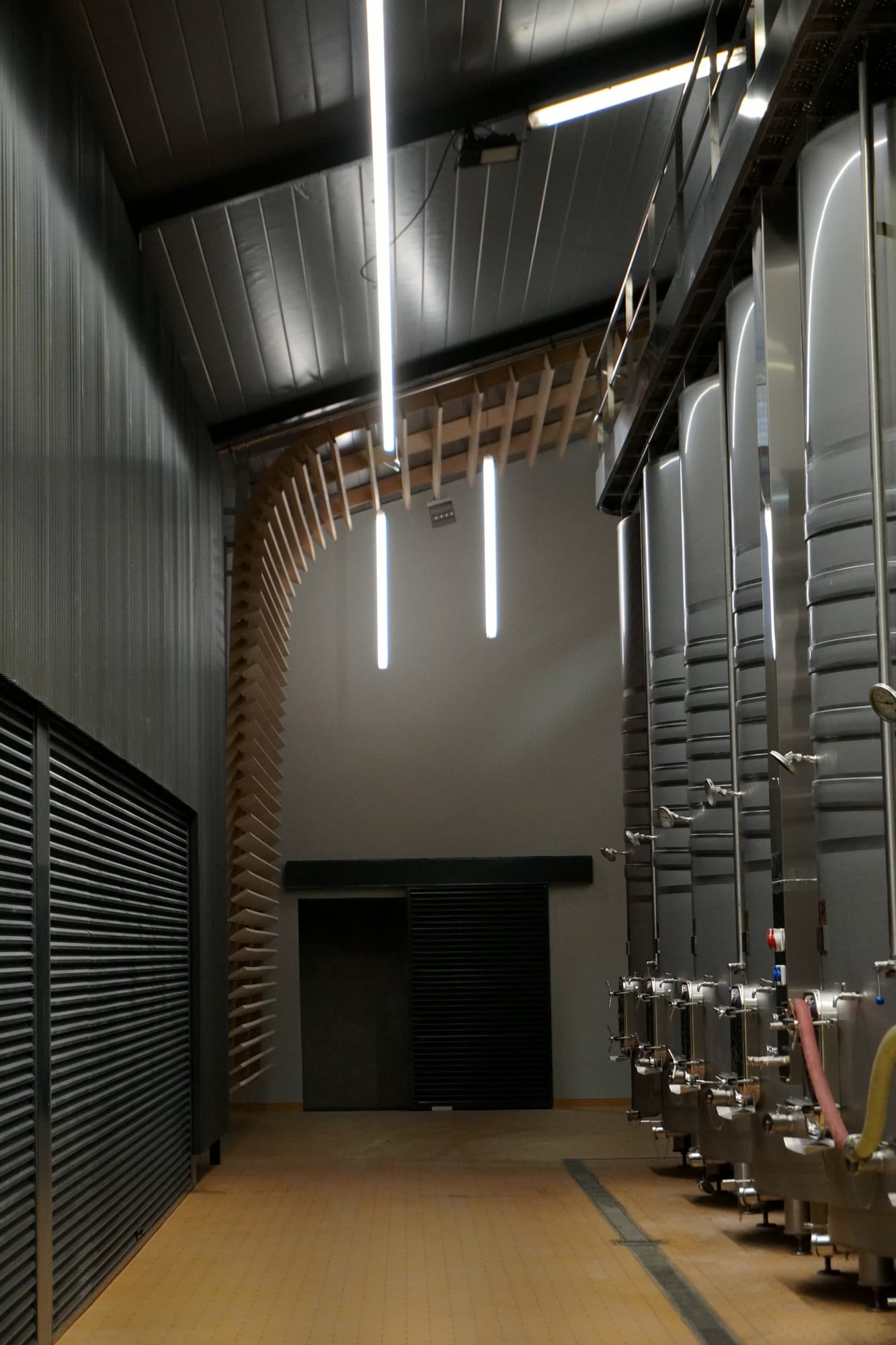 Sala de depósitos con techo oscuro, lamas de madera y una puerta al fondo